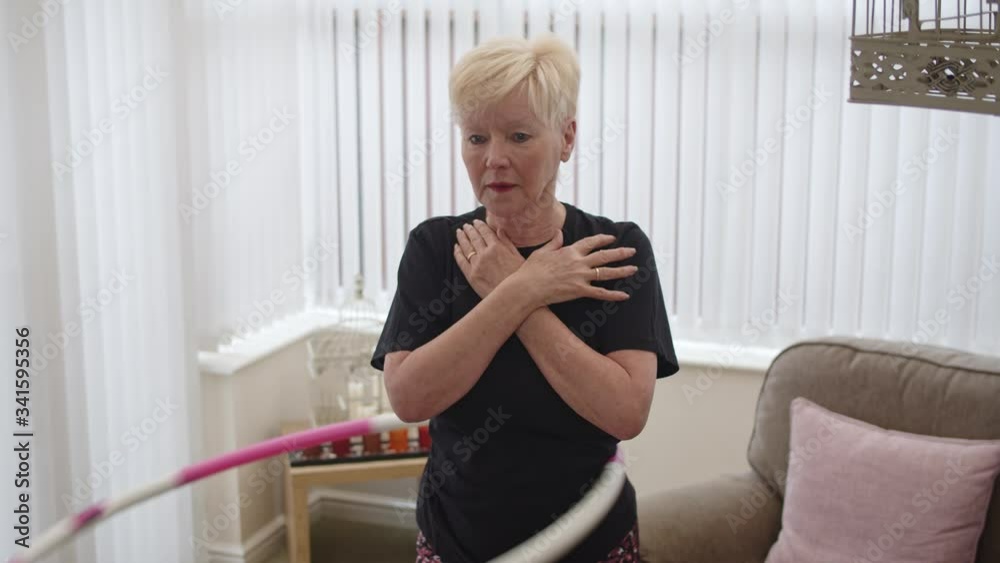 Female using hula hoop to exercise at home spinning hoop on waist with arms crossed. Female using hula hoop to exercise at home spinning hoop on waist with arms crossed.
