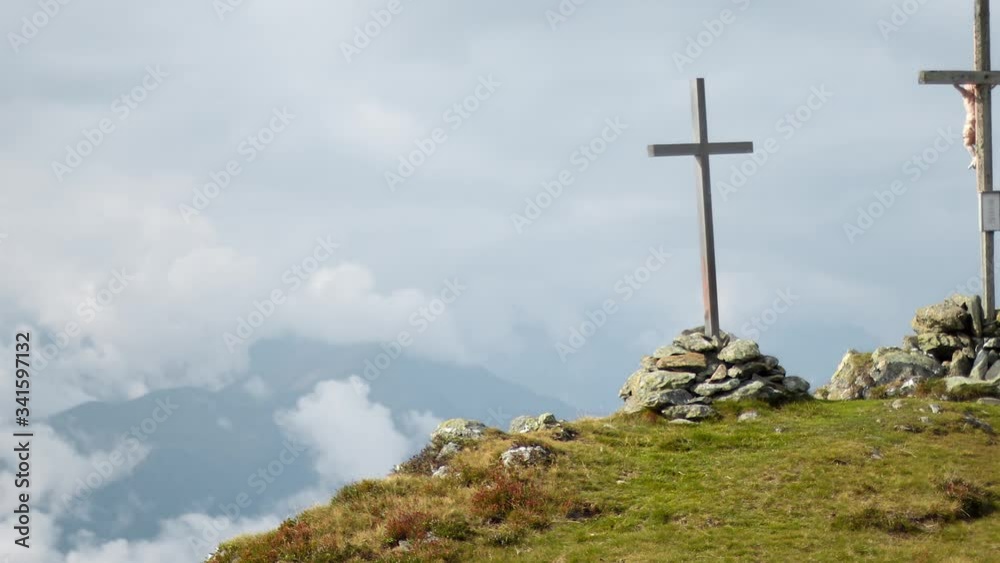 Timelapse zoom out showing three large Christian crosses on top of a mountain. Timelapse showing three crucifixes being held by large stone piles at the peak of a mountain during a cloudy day Timelapse zoom out showing three large Christian crosses on top of a mountain. Timelapse showing three crucifixes being held by large stone piles at the peak of a mountain during a cloudy day