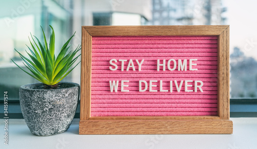 фотографія COVID-19 STAY HOME WE DELIVER Coronavirus social distancing restaurant business message sign with text offering online delivery to home, staying inside