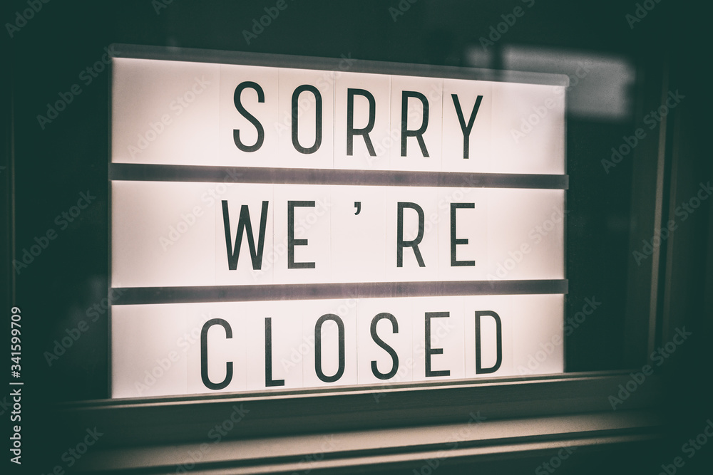 SORRY WE'RE CLOSED storefront window sign. Coronavirus Closure due to COVID-19 message board in business retail store lightbox at night. Shutdown of restaurants, stores, non essential services. SORRY WE'RE CLOSED storefront window sign. Coronavirus Closure due to COVID-19 message board in business retail store lightbox at night. Shutdown of restaurants, stores, non essential services.