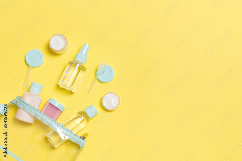Set of travel size cosmetic bottles on yellow background. Flat lay of cream jars. Top view of bodycare style concept Set of travel size cosmetic bottles on yellow background. Flat lay of cream jars. Top view of bodycare style concept