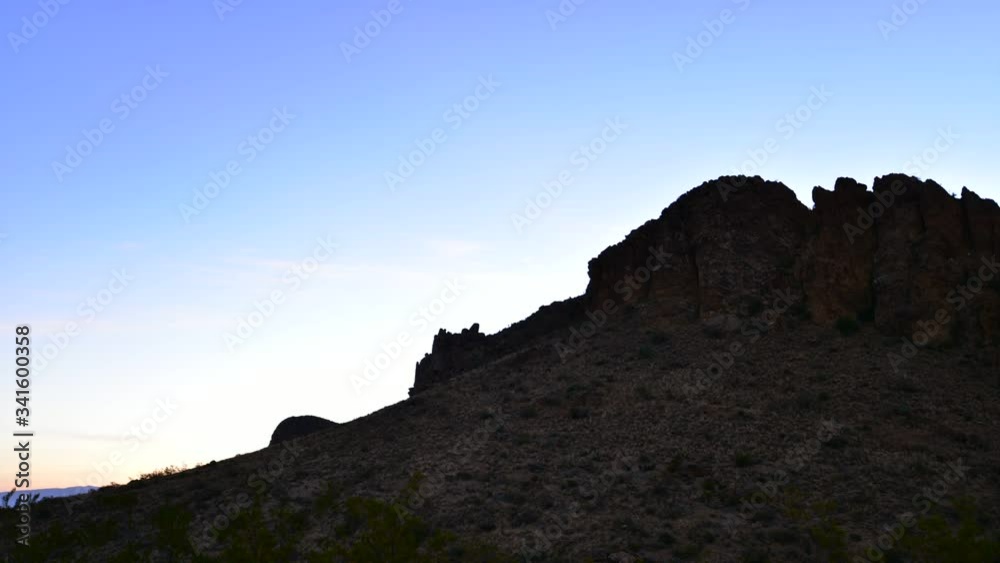 Sunrise time lapse - as the sun rises its light reveals rugged mountain terrain Sunrise time lapse - as the sun rises its light reveals rugged mountain terrain