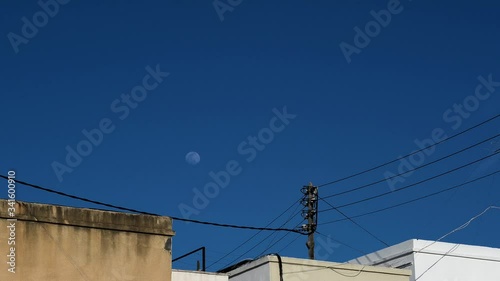 Timelapse 4k of moon and blue sky over the city Valencia, Spain.