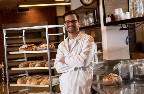 Obraz na płótnie Portrait of young male baker standing at bakery.