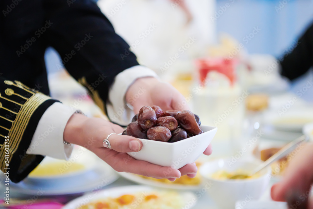 Muslim family having Iftar dinner eating dates to break feast Muslim family having Iftar dinner eating dates to break feast