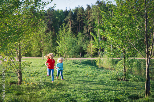 happy little girls run and play in summer nature