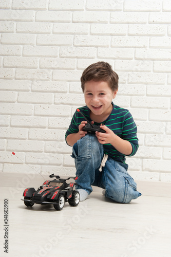 boy with toy car against a brick wall