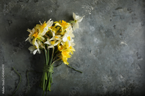 Beautiful bouquet of yellow daffodils on an dark green gray background. Copy space. Can be used as a card  background for screensavers  greetings.
