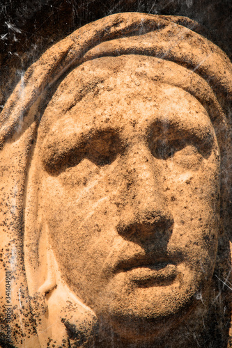 Retro styled sad eyes view of Virgin Mary. Vintage stone statue of woman in grief