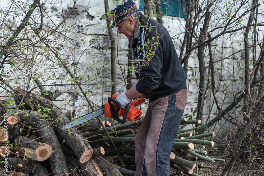 Obraz premium Elderly man is engaged in a hobby of construction and work in the yard.