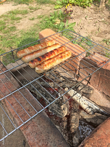 On a grill grate fresh grilled sausages. Char cooked meat