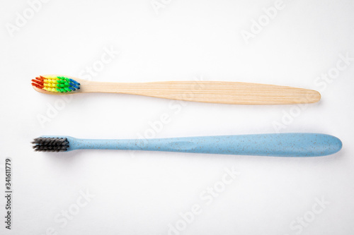 Plastic and bamboo toothbrushes on a white background