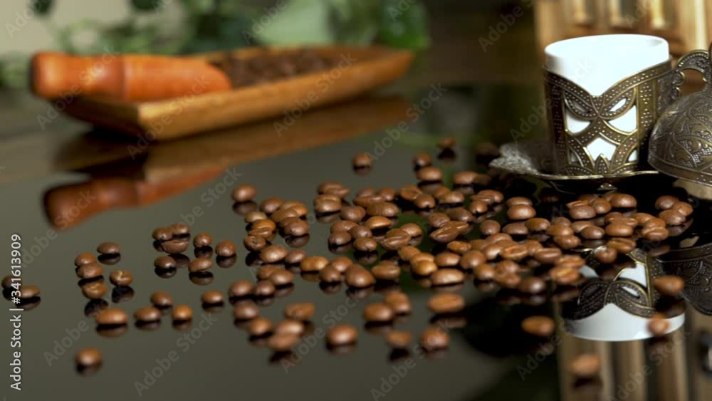 Coffee beans on dark surface with antique coffee copper cup. Sliding 4K video shot of commercial coffee concept in slow motion 30fps. Coffee beans on dark surface with antique coffee copper cup. Sliding 4K video shot of commercial coffee concept in slow motion 30fps.