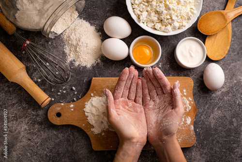 Girl's hands in flour cooking homemade pie. Healthy food. Top view.