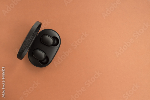  flat layout with wireless headphones in a black box. brown background. Card with copy space for text