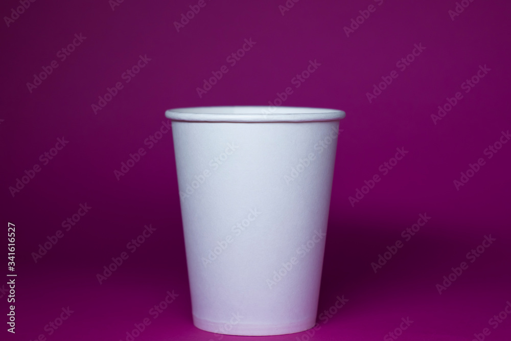 An empty white paper cup on a pink background An empty white paper cup on a pink background