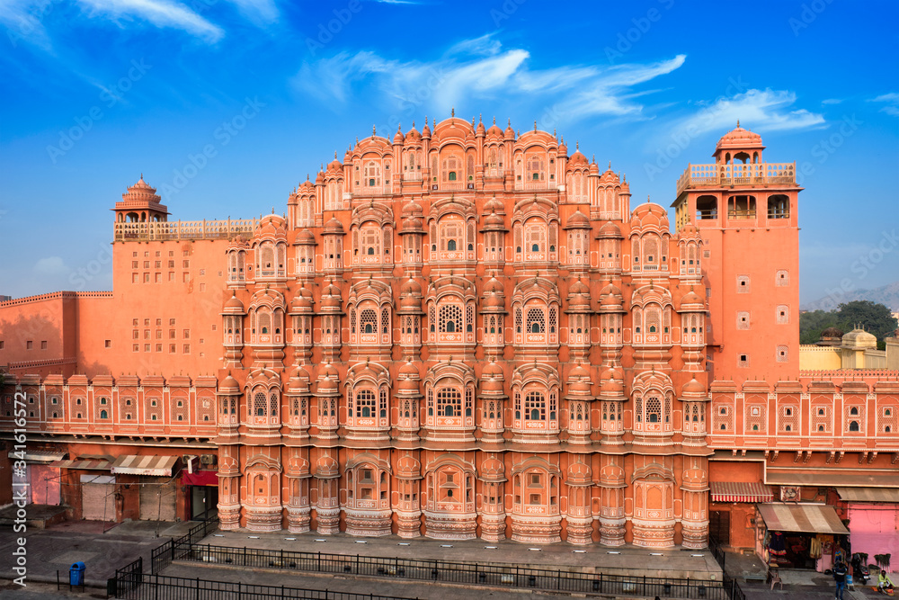 Famous landmak pink Hawa Mahal Palace of winds with people, road traffic and city transport. Mughal art cultural heritage famous tourist attraction. Jaipur, Rajasthan, India