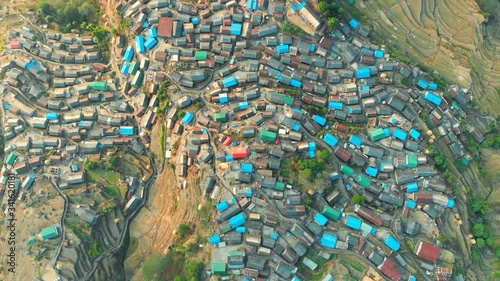 Birdeye view of the largest Gurung village Bhujung on a slope of a hill. Evening wide shot from above with a drone flying over the village cluster in Lamjung, Gandaki, Nepal. photo