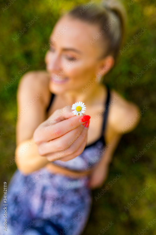 Frau mit Blume, Gänseblümchen, lacht und genießt die Sonne, liegend im Gras , draufsicht Frau mit Blume, Gänseblümchen, lacht und genießt die Sonne, liegend im Gras , draufsicht