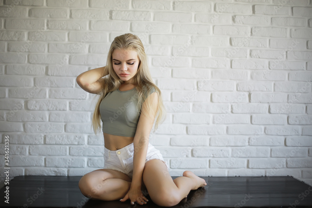girl in a loft interior, modern house, windows, wall. young adult posing