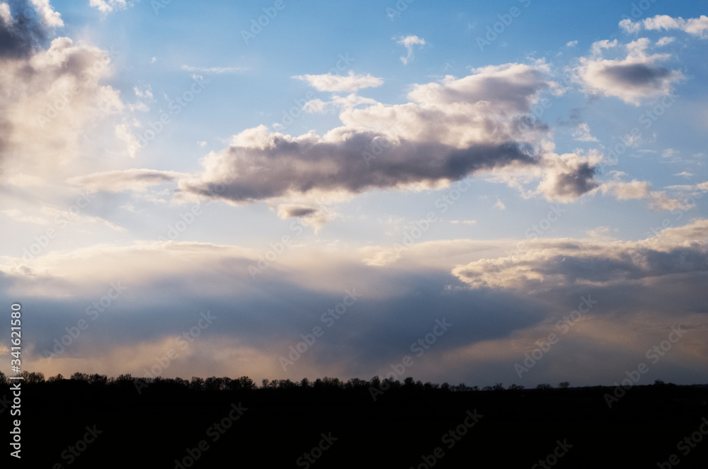 Beautiful cloudy evening sky over a field at sunset
Beautiful cloudy evening sky over a field at sunset