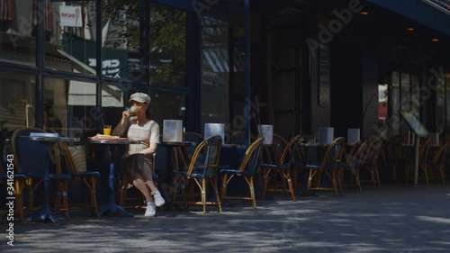 Young attractive woman in a cafe in Paris outdoors