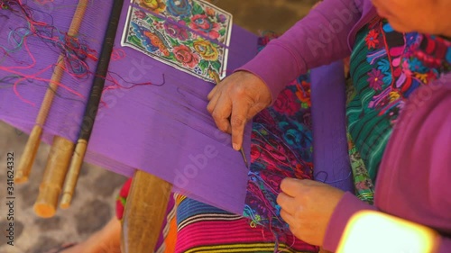 Guatemalan woman weaving blanket on a loom High Angle photo