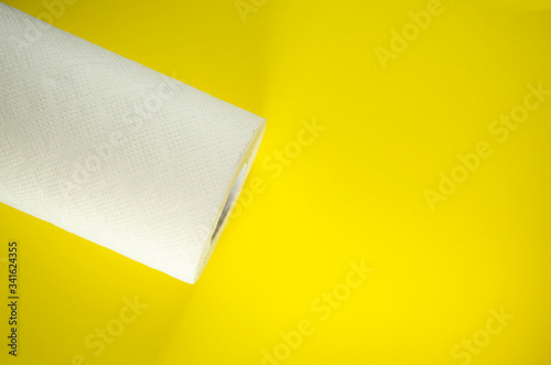 Toilet paper top view. Paper towel roll on the yellow background. Hygiene stuff for everyday. Banner template with body care products and copy space. Selective focus