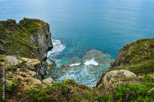 Top view of the turquoise seabed framed by cliffs with grass © Tishina