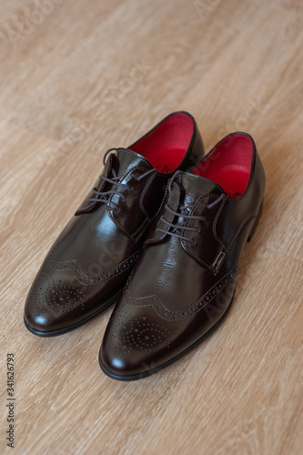 Brown shoes for men on a wooden background.