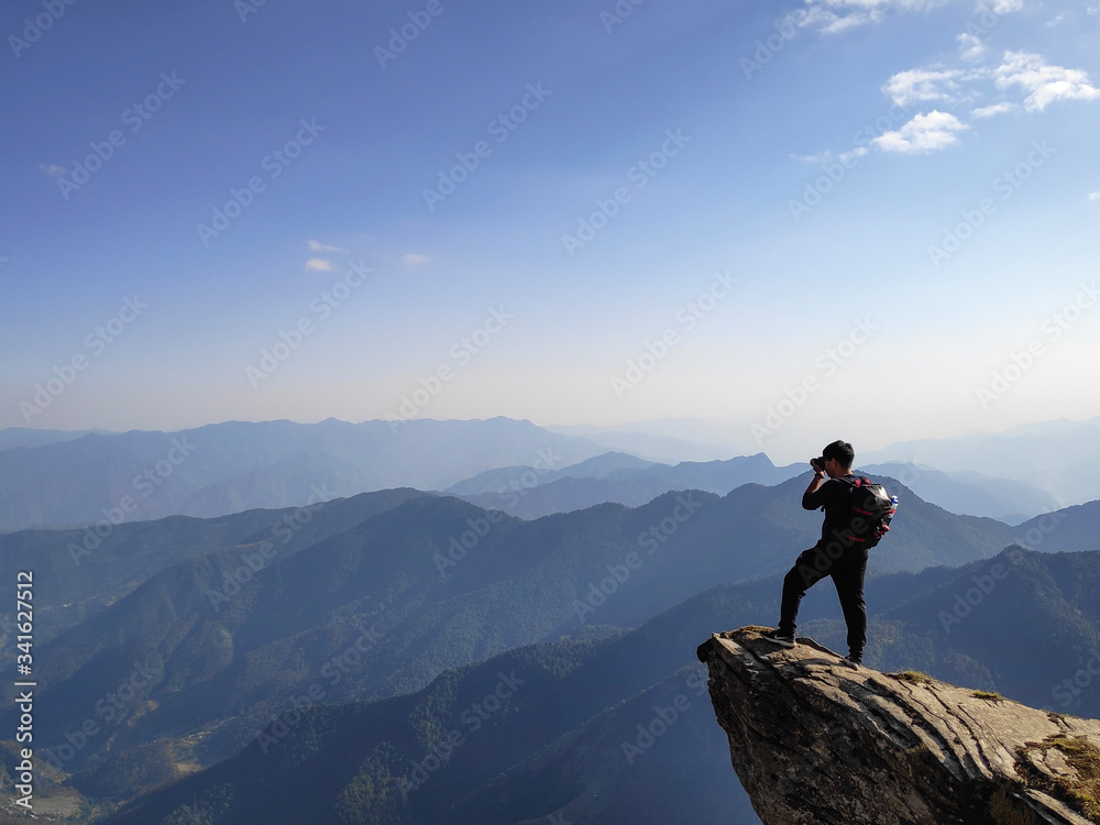 Photographer On The Edge of A Cliff in The Mountains
