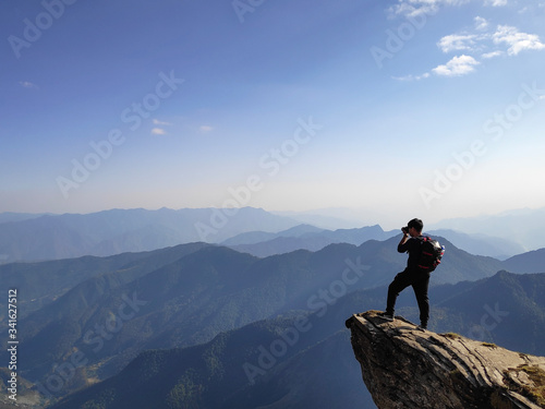 Photographer On The Edge of A Cliff in The Mountains