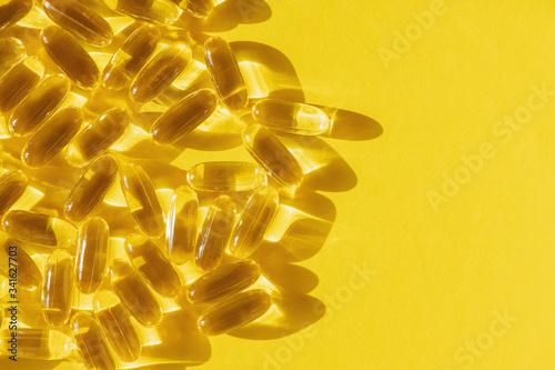 Fish oil capsules on yellow background