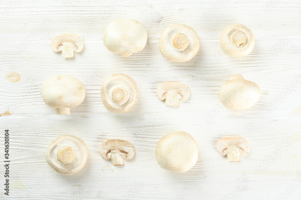 Bunch of farm raised organic mushrooms laid in composition on textured background. Champignons on table counter. Clean eating concept. Background, close up, flat lay, top view. Bunch of farm raised organic mushrooms laid in composition on textured background. Champignons on table counter. Clean eating concept. Background, close up, flat lay, top view.