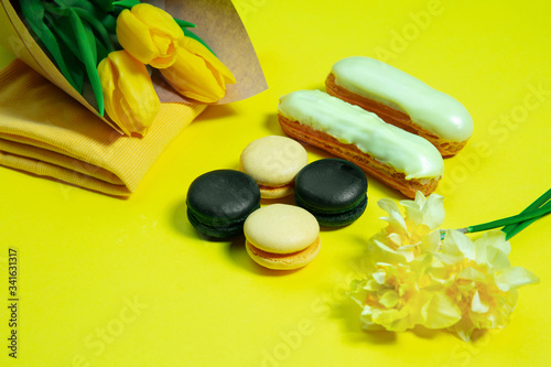 Fototapeta Naklejka Na Ścianę i Meble -  Macaroons and flowers. Monochrome stylish and trendy composition in yellow color on studio background. Top view, flat lay. Pure beauty of usual things around. Copyspace for ad. Holiday, food, fashion.