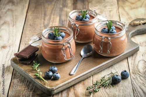 Chocolate mousse in glass jar with berries on a rustic background copy space. Homemade dessert.