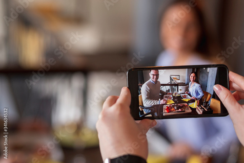 Couple being photographed during lunch in restaurant