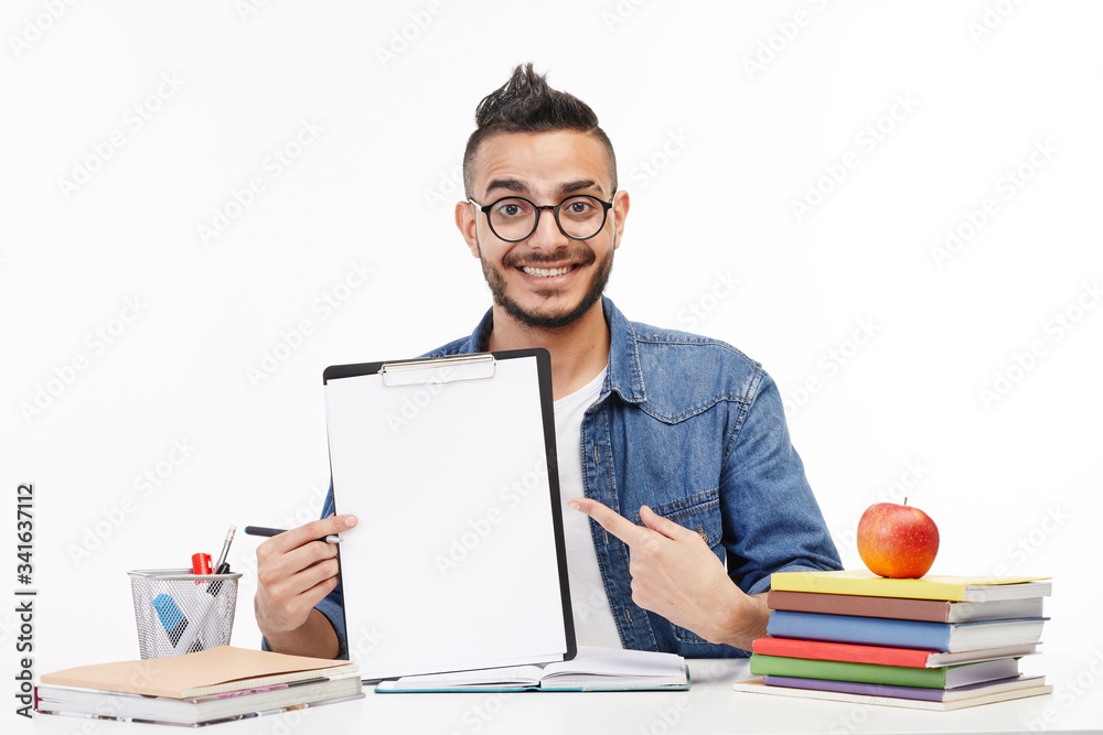 Smiling college student shows his notepad at the camera. Smiling college student shows his notepad at the camera.