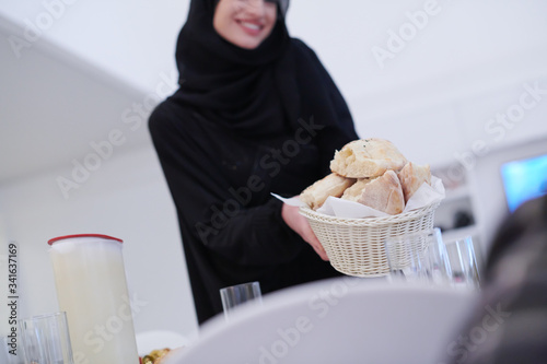 young muslim girl serving food on the table for iftar dinner