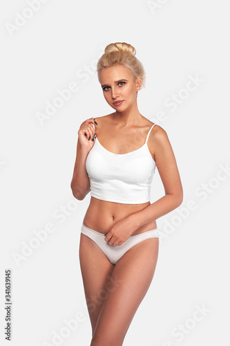 Young, slim, healthy and beautiful blonde woman in white lingerie. Sport, fitness, diet, weight loss and healthcare concept. Mockup.