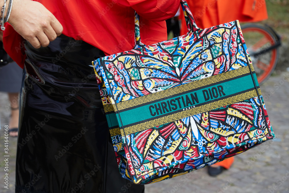 Woman with Christian Dior colorful bag and red shirt on September 22, 2018  in Milan, Italy Stock Photo | Adobe Stock