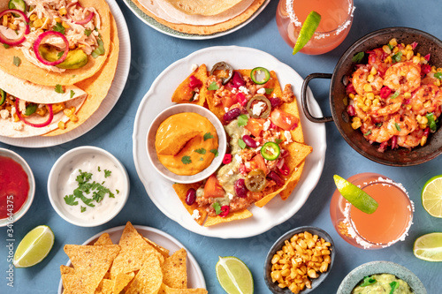 Mexican food, a flat lay. Nachos, tortillas, Paloma cocktails and other dishes, shot from the top