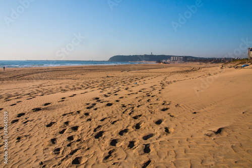 Footprints in Damp Beach Sand with Bluff in Background