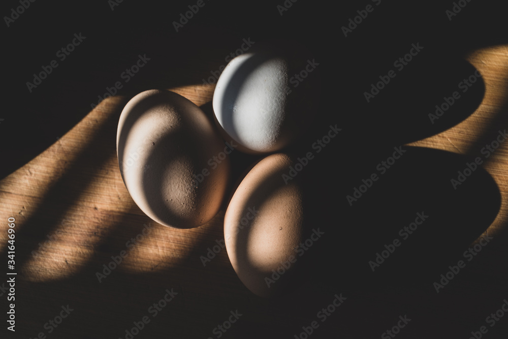 fresh chicken eggs lie on a wooden Board, warmly illuminated by a beautiful warm light