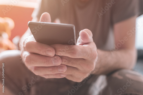 Fotografía Man using mobile phone at home