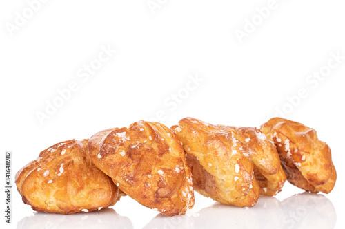 Group of five whole fresh baked profiterole in row isolated on white