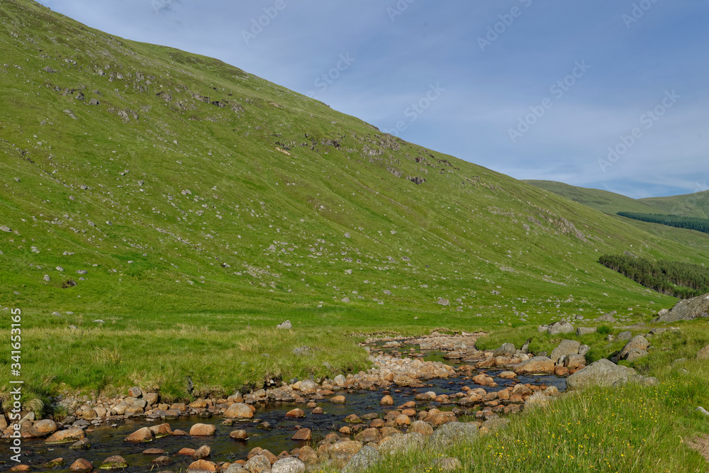 A small Stream beside an old ruined Stone sheep pen on the Valley side of Glen Doll on a bright day in July. A small Stream beside an old ruined Stone sheep pen on the Valley side of Glen Doll on a bright day in July.