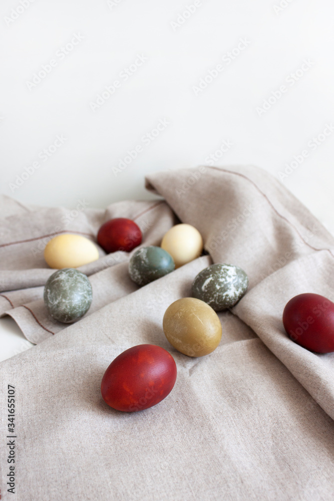 Rustic background. Colored eggs on a woven fabric. Easter