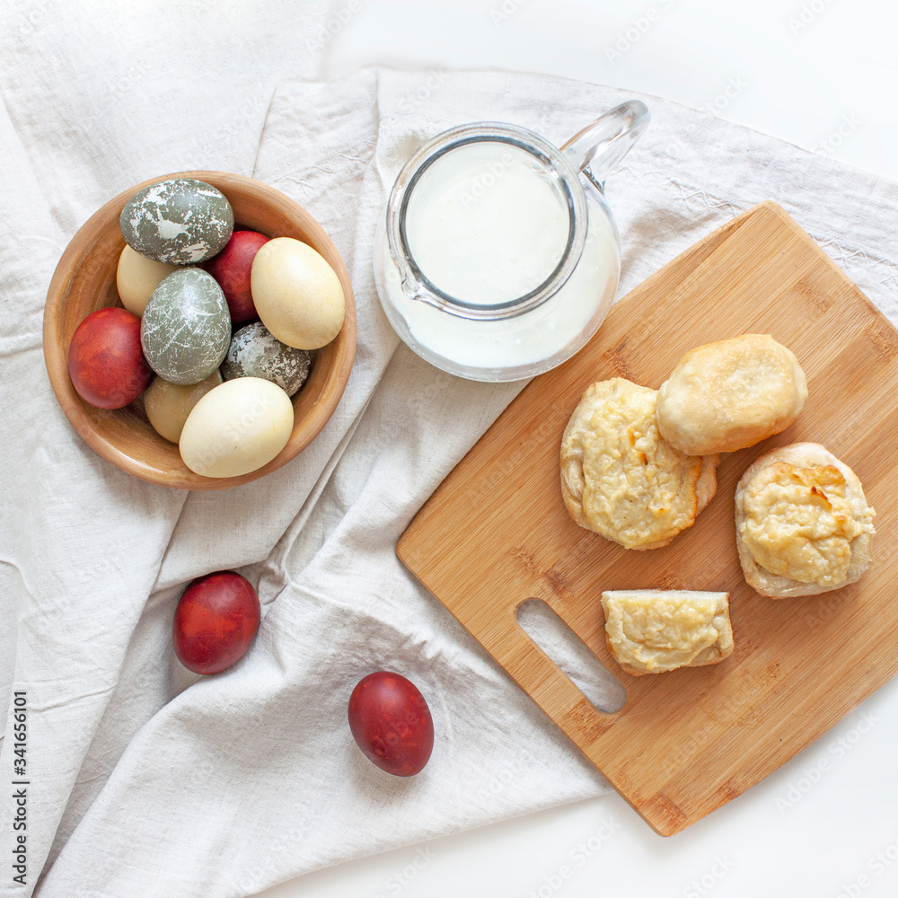 Rustic background. Easter. Colored eggs, milk and homemade bakery products