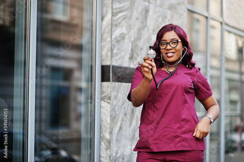 African american female doctor at red lab uniform with stethoscope. Medicine, profession and healthcare concept. © AS Photo Family